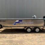 a small Franmarine work boat called Eclipse with a Suzuki engin outside a warehouse