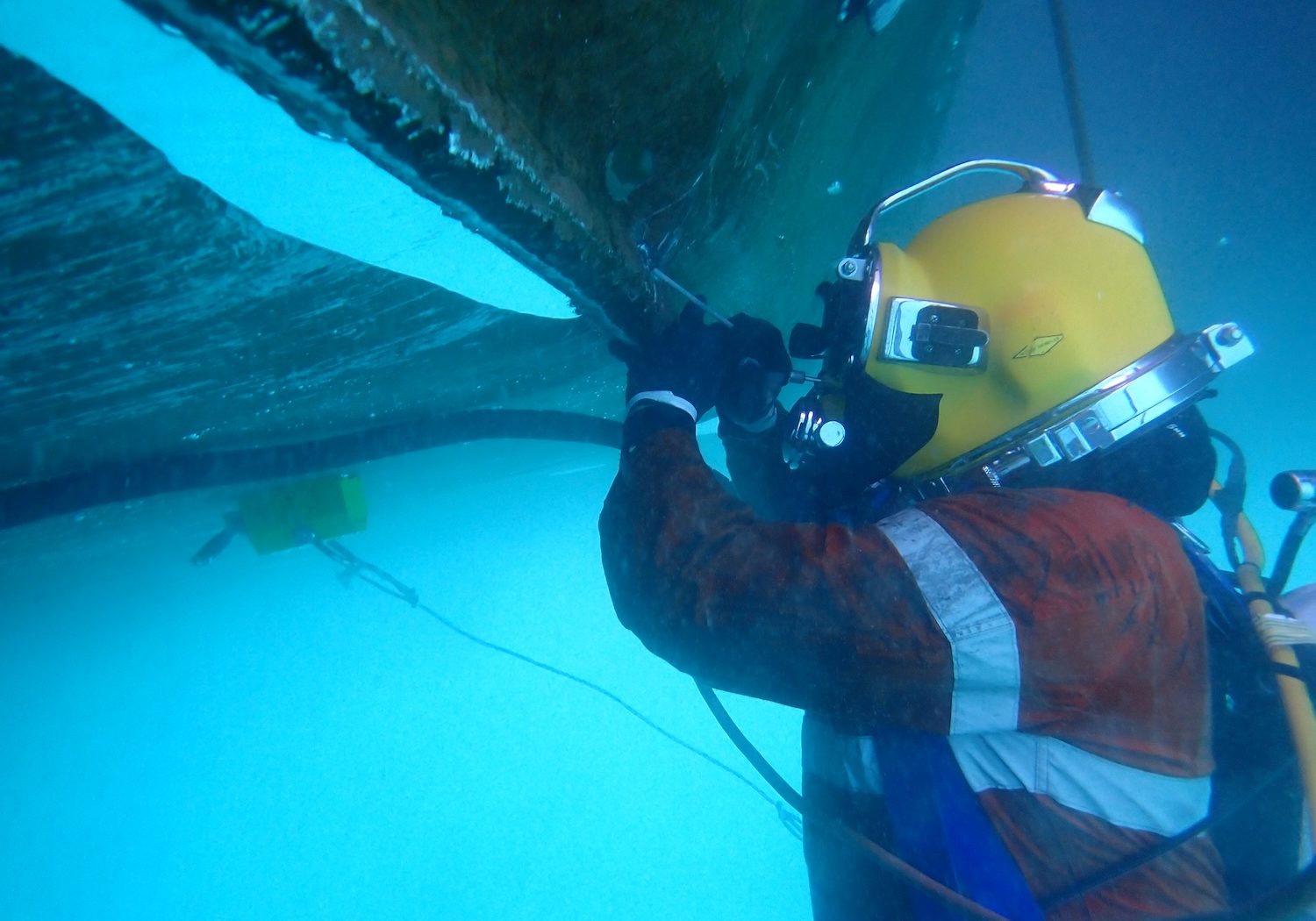 commercial diver working on ship hull underwater
