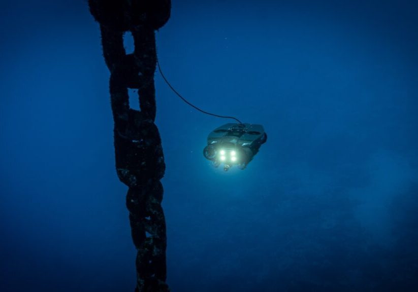 underwater remote operating vehicle approaching a large shipping chain