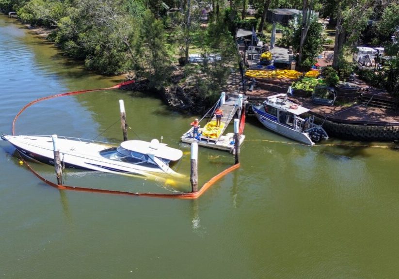 small motor boat submerged half way under water depicting marine salvage